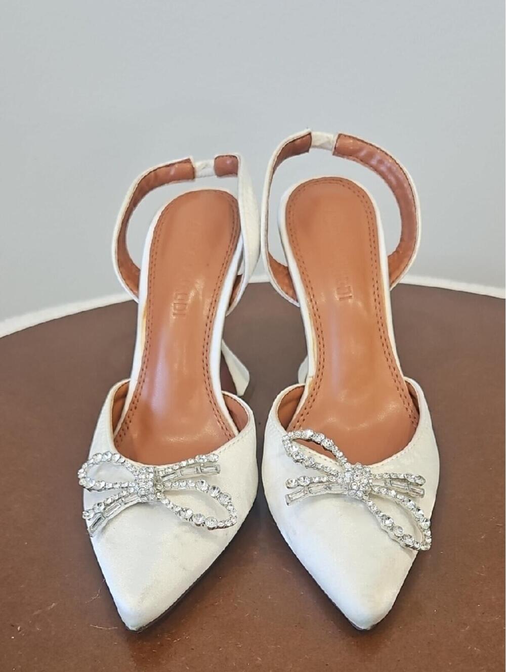 Amina Muaddi White Pointed Slingback Heels with Crystal Bow